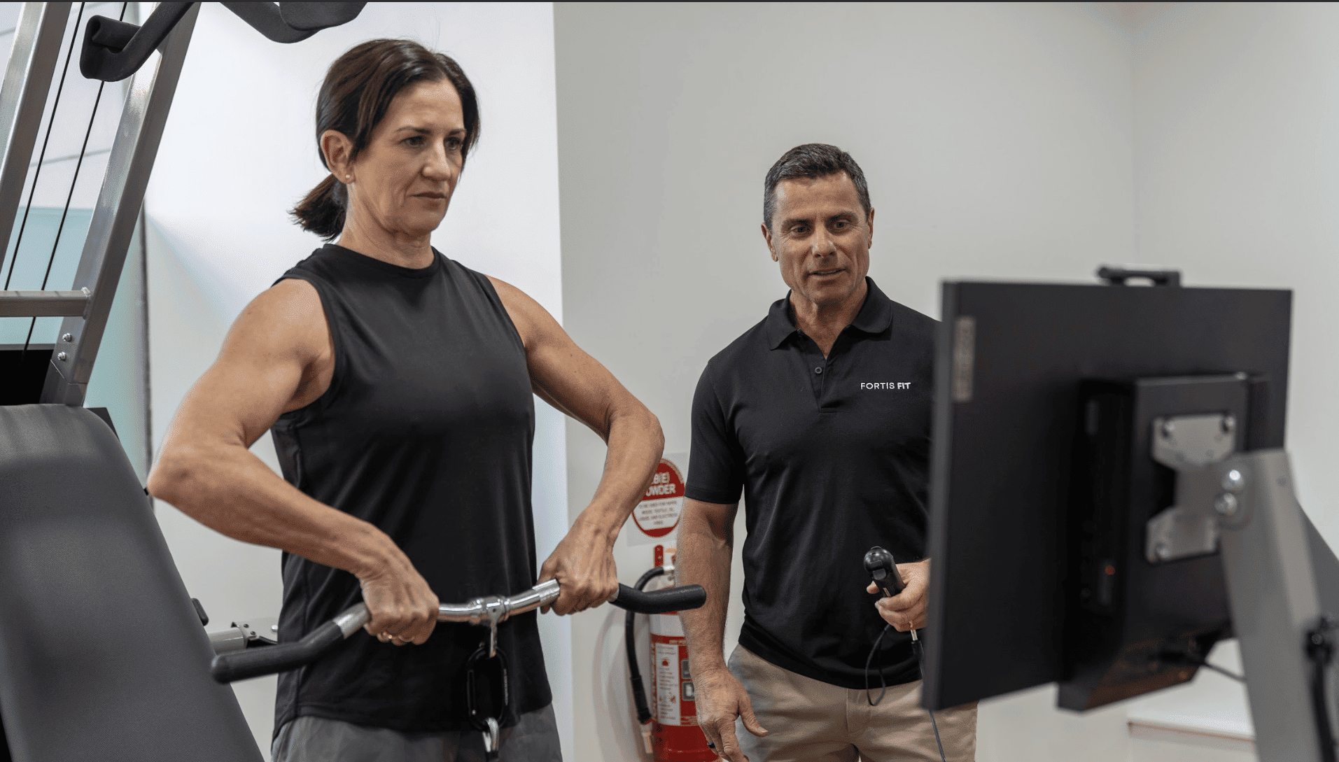 Personal trainer assisting a female client with strength training and weight loss at Fortis Fit Personal Training in Sydney.