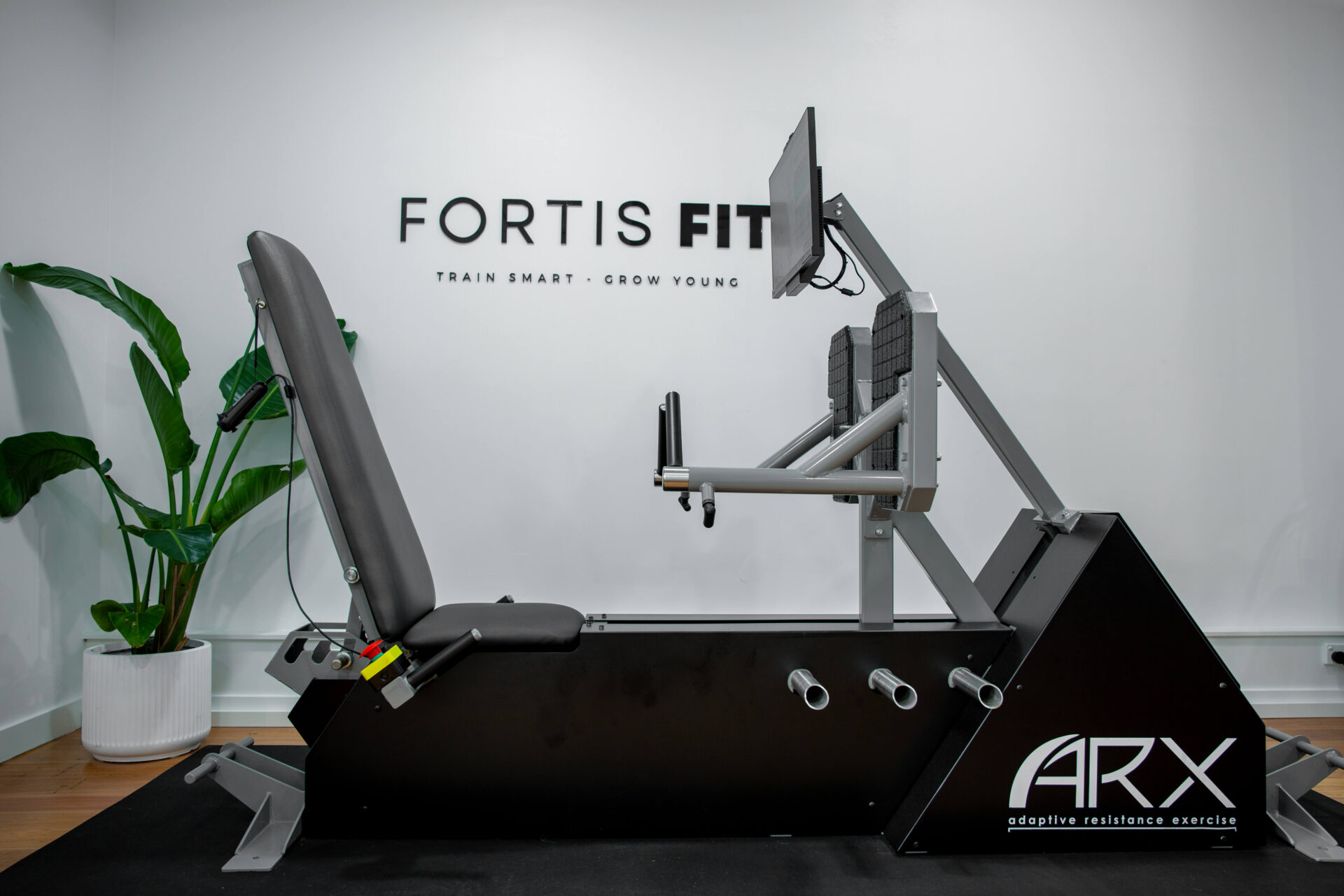 Personal trainer assisting a client with using the ARX adaptive resistance machine at Fortis Fit Personal Training in Sydney.